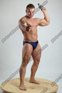 ADAM WARD STANDING WITH TWO GUNS